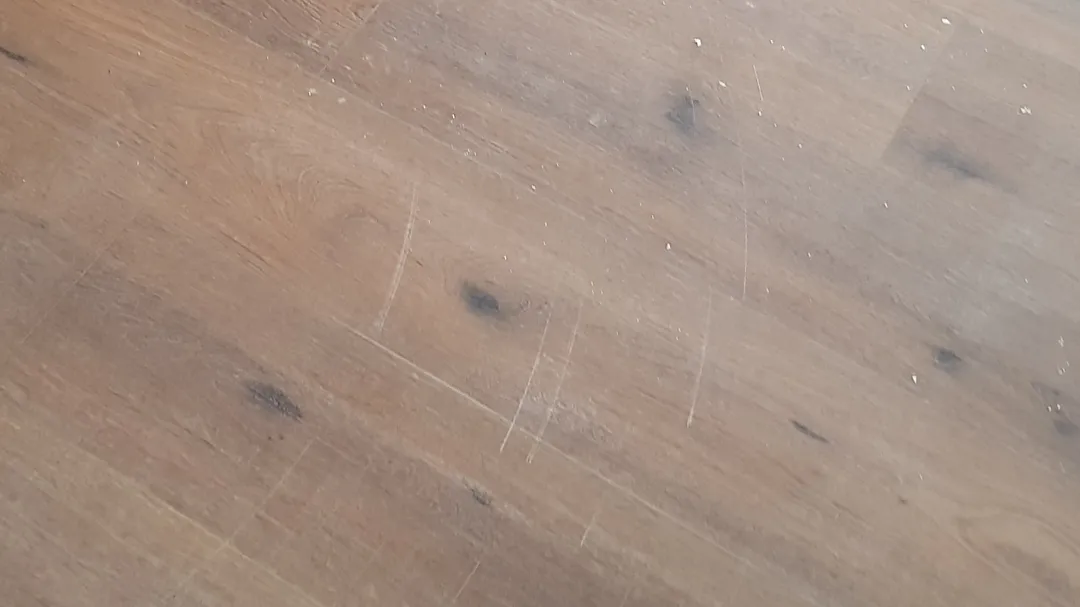 Scratches on the floor made by front door on dirty floor