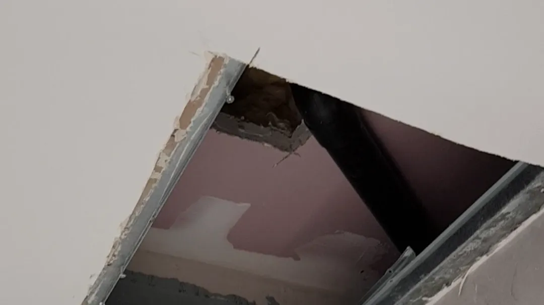 Hole in the bathroom ceiling, above bathtub